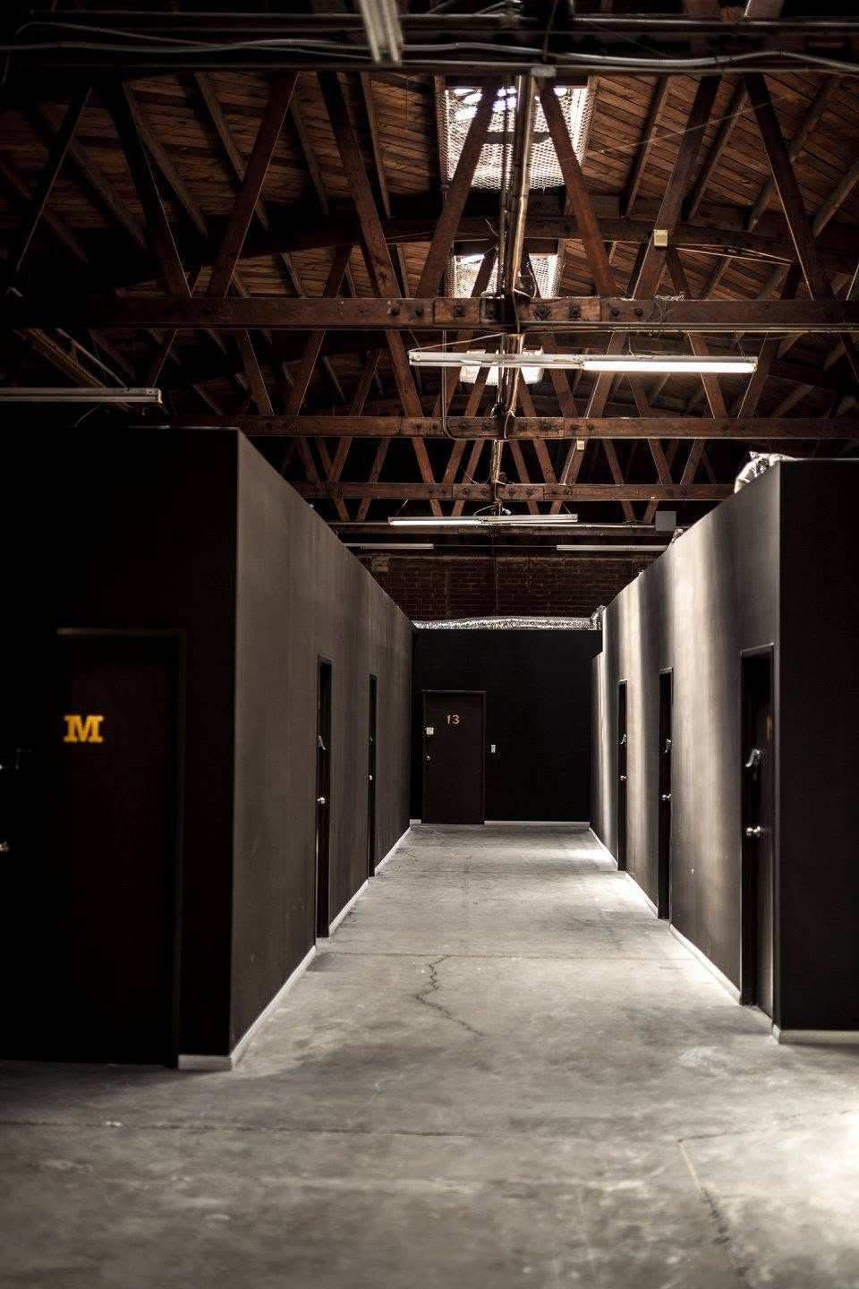 Long corridor of studio doors under the bow-truss ceiling